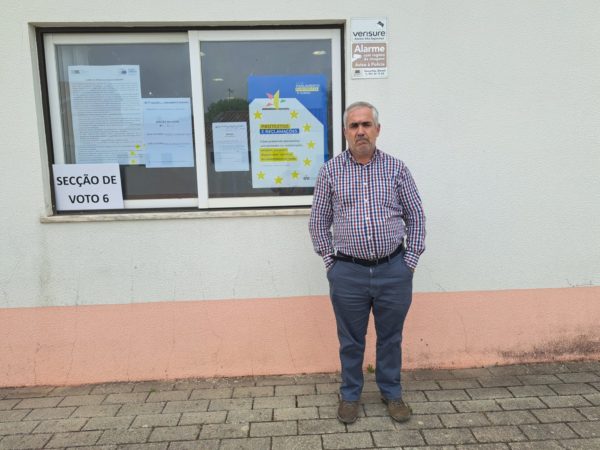 Rui Coimbras, a disability activist poses in front of a polling station with hands in his pockets